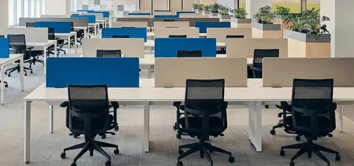 Modern open-plan office space featuring clean workstations, ergonomic chairs, and sanitized carpets provided by professional office cleaning services in Raleigh, NC.
